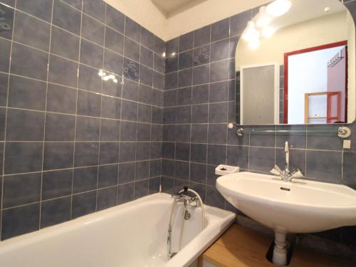 a bathroom with a sink and a tub and a mirror at Studio Lanslevillard, 1 pièce, 4 personnes - FR-1-508-206 in Lanslevillard