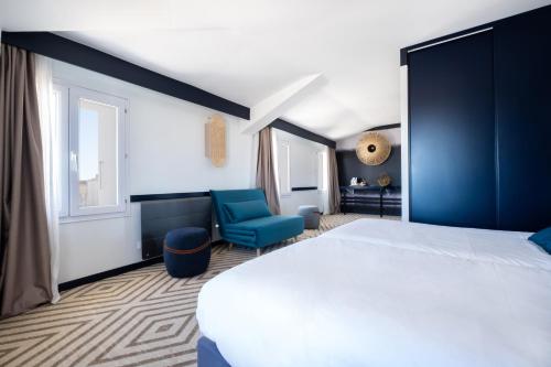 ein Schlafzimmer mit einem weißen Bett und blauen Stühlen in der Unterkunft Hôtel Le Français in La Flotte