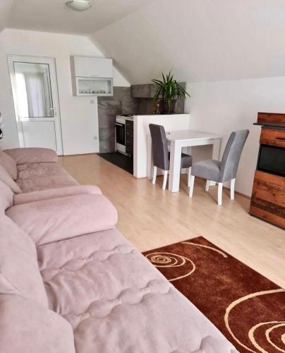 sala de estar con cama, mesa y sillas en Apartman K3, en Kraljevo
