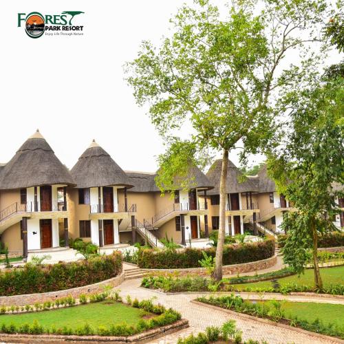 a row of houses with thatched roofs and a garden at Forest Park Resort in Buloba