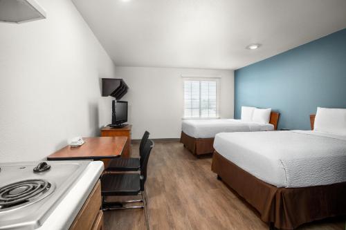 a small hotel room with two beds and a stove at Extended Stay America Select Suites - Gulfport in Gulfport