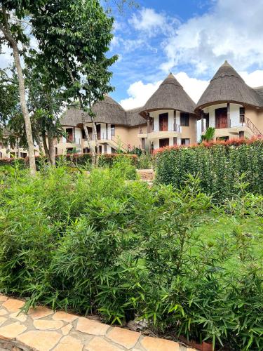 a row of houses with thatched roofs at Forest Park Resort in Buloba
