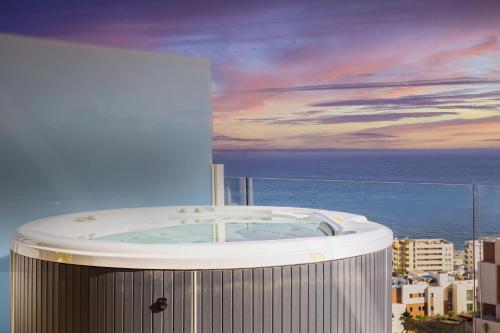 a hot tub on top of a building with the ocean at Ensuite Deluxe Jacuzzi & Parking Privado in Fuengirola