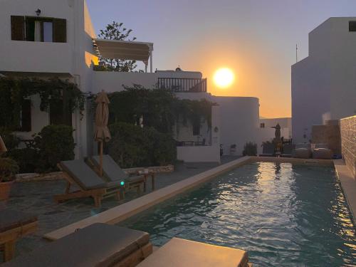 a swimming pool with a sunset in the background at Christina Hotel, Adults Only in Naousa