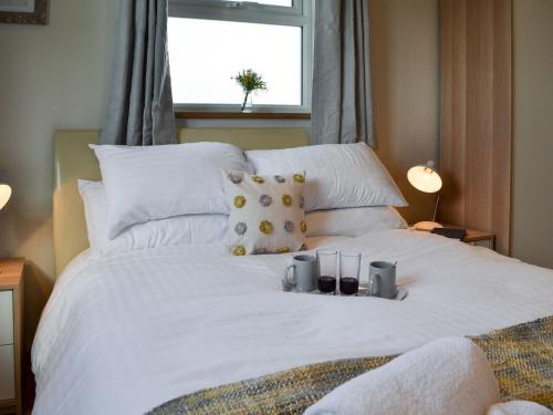 a white bed with two candles on top of it at The Hayloft-ukc2489 in Mountfield