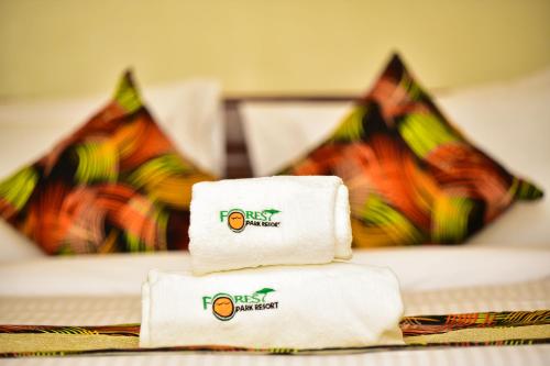 a pile of folded towels sitting on a bed at Forest Park Resort in Buloba