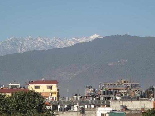 a group of buildings with mountains in the background at Kathmandu Madhuban Guest House in Kathmandu