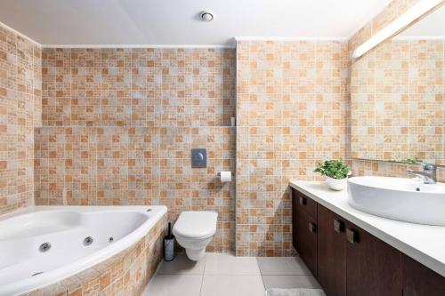 a bathroom with a tub and a toilet and a sink at Blue Dream Marina View big 1bd ap pool parkimg gym in Herzliyya B