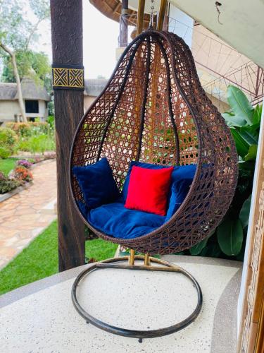 a hanging chair with two pillows on a porch at Forest Park Resort in Buloba