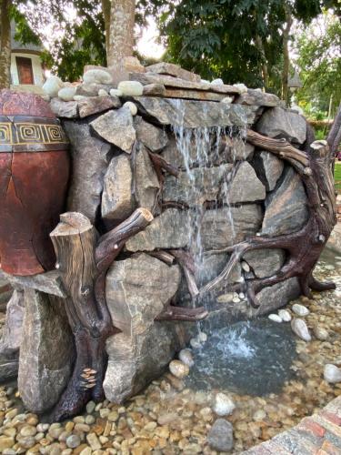 a waterfall in a rock fountain in a garden at Forest Park Resort in Buloba