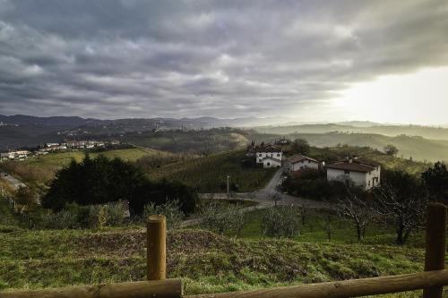 a view of a village on a hill with a fence at B&B Calligaris in Dobrovo