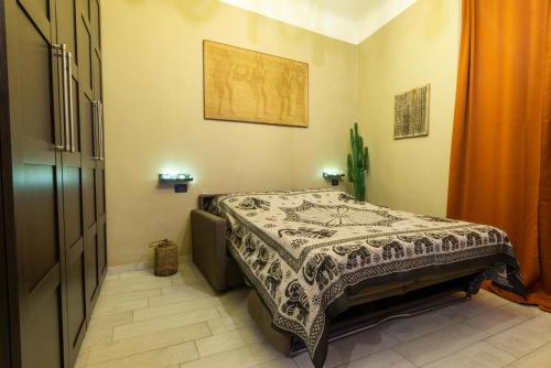 ein Schlafzimmer mit einem Bett mit einer Decke darauf in der Unterkunft Monolocale vicino alla Stazione e all’Expò in Genua