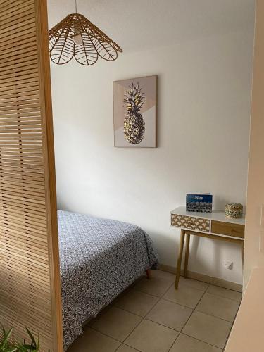 - une chambre avec un lit et une photo d'ananas sur le mur dans l'établissement Studio cosy tout équipé 30m2, à Nice
