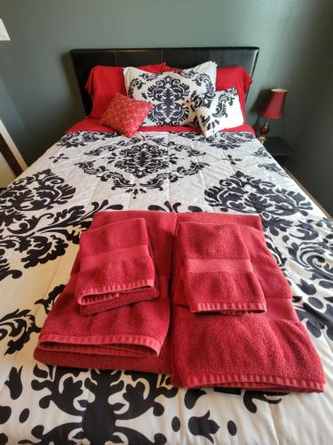 a bed with red blankets and pillows on it at Modern, Private, Smart 4 BR Condo in Desirable Location in McAllen with Pool! in McAllen