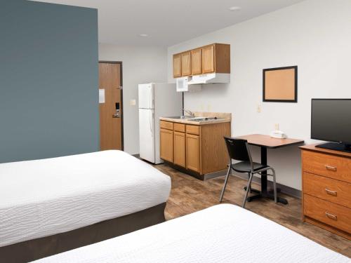 a hotel room with two beds and a desk with a computer at Extended Stay America Select Suites - Kalamazoo - West in Kalamazoo