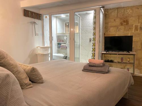 a bedroom with a large bed and a television at Moi in Birkirkara