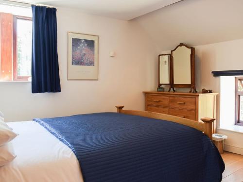 1 dormitorio con cama, tocador y espejo en The Granary, en Westerdale