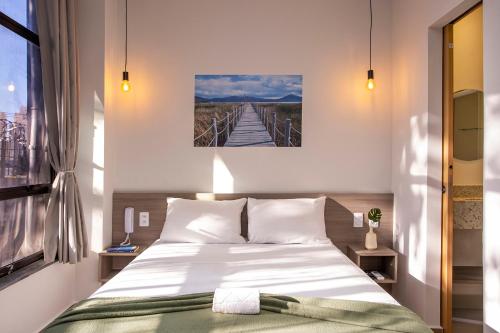 a bedroom with a bed and a bridge painting on the wall at GoÁtica Aeroporto Congonhas in São Paulo