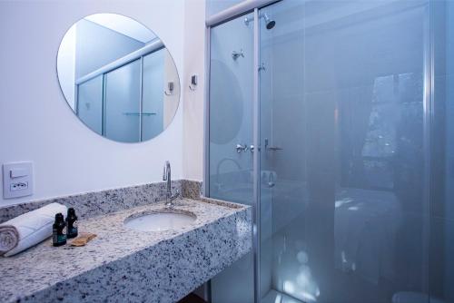 a bathroom with a shower and a sink and a mirror at GoÁtica Aeroporto Congonhas in Sao Paulo
