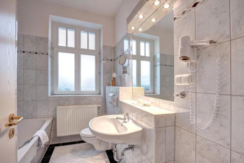 a white bathroom with a sink and a shower at Haus Seeblick Hotel Garni & Ferienwohnungen in Zinnowitz