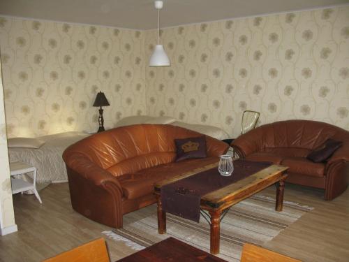 a living room with two leather couches and a coffee table at Västerdala Onwest in Äppelbo