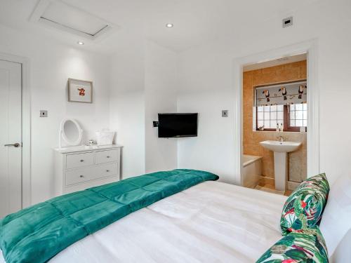 a bedroom with a bed with a green blanket on it at The Birds Nest in Longridge