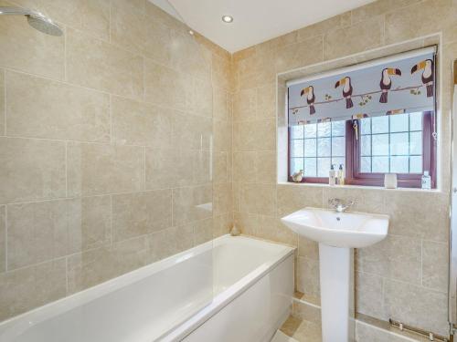 a bathroom with a tub and a sink and a bath tubermott at The Birds Nest in Longridge