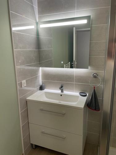 ein Badezimmer mit einem weißen Waschbecken und einem Spiegel in der Unterkunft Gite d Annie et J-louis 