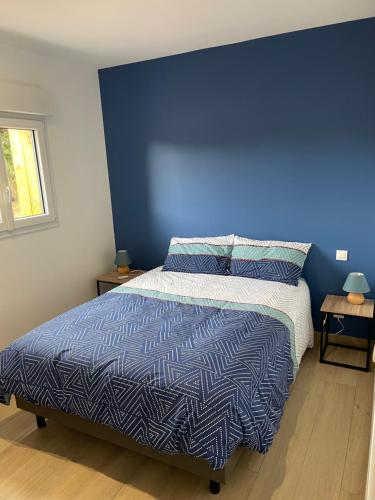 een slaapkamer met een blauwe muur en een bed bij Gite d Annie et J-louis 