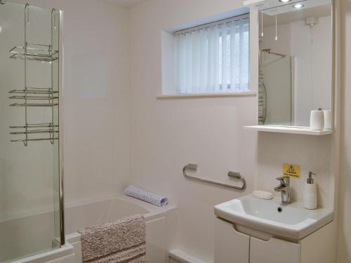 a white bathroom with a sink and a shower at Cilgwyn in Llandecwyn