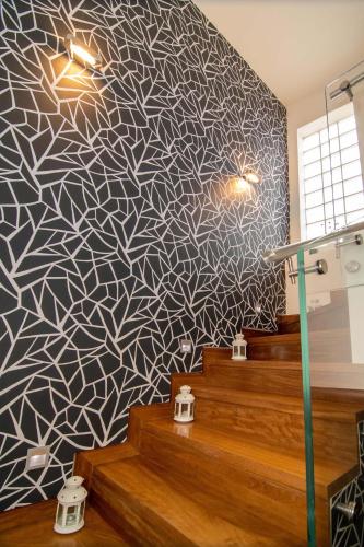 a room with a patterned wall with stairs and lights at Optasia Luxury House in Argos