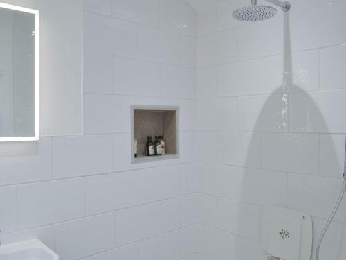 a white bathroom with a tub and a shower at The Milking Parlour in Keevil