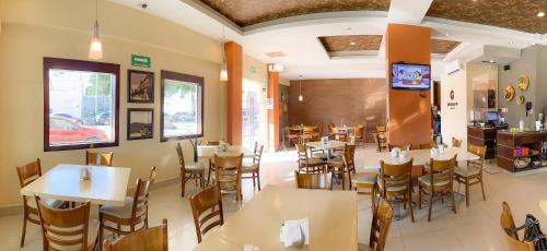 un comedor con mesas y sillas en un restaurante en Hotel Fenix, en Los Mochis