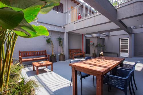 a patio with a wooden table and chairs at GoÁtica Aeroporto Congonhas in Sao Paulo