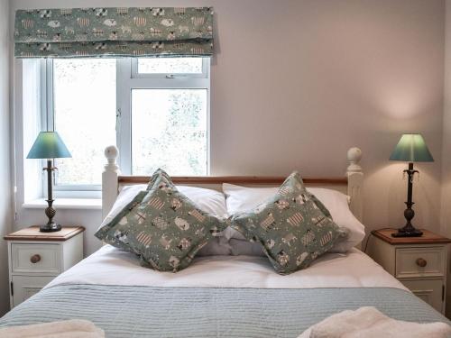 1 dormitorio con cama con almohadas y ventana en The Sheep Shed - Uk38437 en Kilham