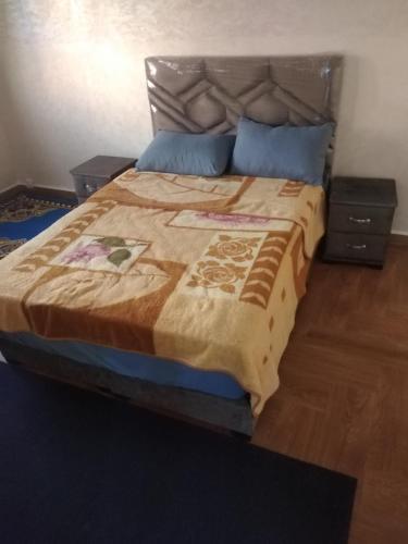 a bedroom with a large bed with two night stands at لبلازا la plaza in Laayoune