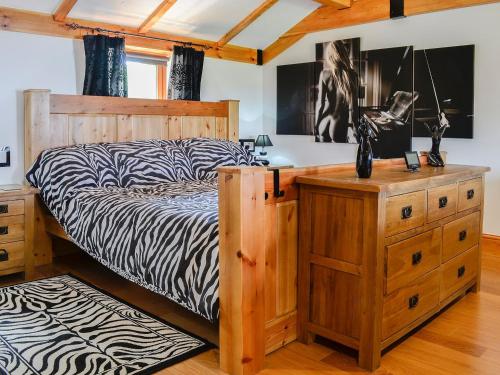 um quarto com uma cama com lençóis estampados de zebra em Swallow Cottage - Ukc3427 em Dalston