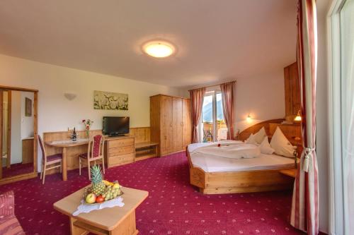 um quarto de hotel com duas camas e uma mesa em Pension Verdinserhöhe em Schenna