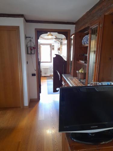a living room with a television and a hallway at Attico Vittoria in Rivisondoli