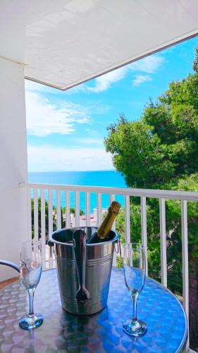 a bottle of wine in a bucket on a table with glasses at Apartamento Ginette SunBeach in Salou