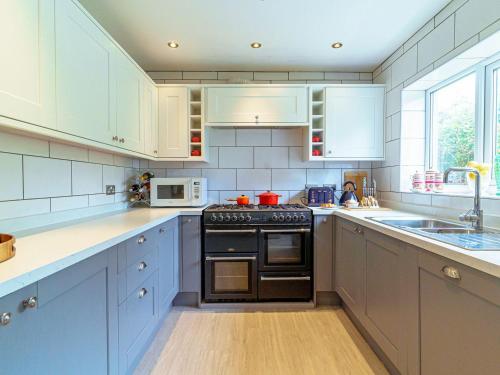 a kitchen with white cabinets and a black stove top oven at Y Graiglwyd in Amlwch