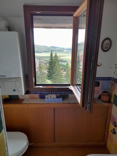 a bathroom with a window with a view at Attico Vittoria in Rivisondoli
