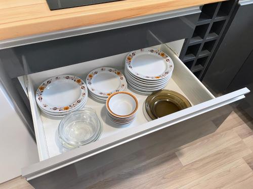 a group of plates and bowls in a drawer at Jóleső Pihenő in Inárcs