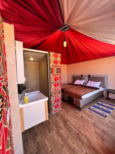 - une chambre avec un lit et un plafond rouge dans l'établissement Rum Crown, à Wadi Rum