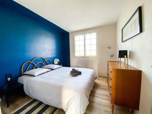 a bedroom with a bed with a cat laying on it at Appartement avec vue sur la tour de Vésone in Périgueux