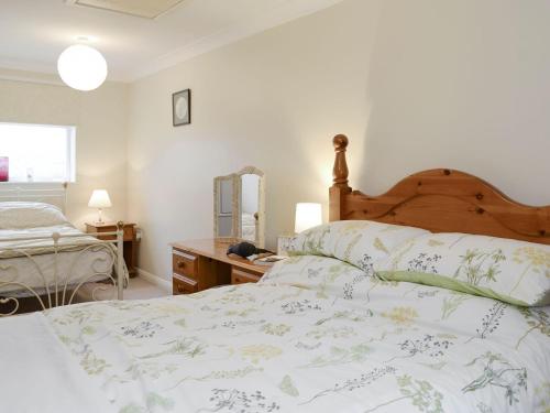 a bedroom with a bed and a dresser and a mirror at The Annexe in Knaresborough