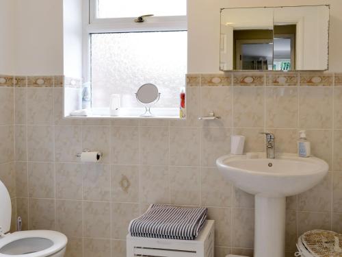 W łazience znajduje się umywalka, toaleta i lustro. w obiekcie The Annexe w mieście Knaresborough