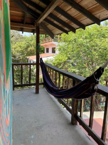 a hammock hanging from a wooden railing on a porch at Casa del Sol in Montañita