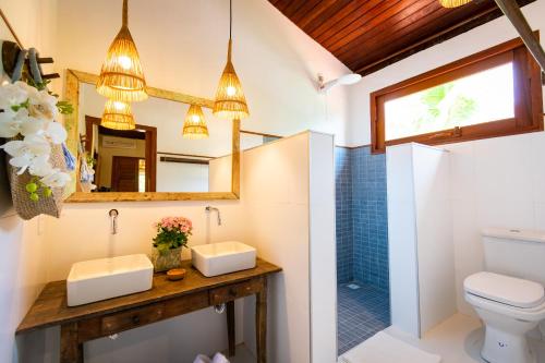 a bathroom with a toilet and a mirror at Casa João Viera Trancoso in Trancoso