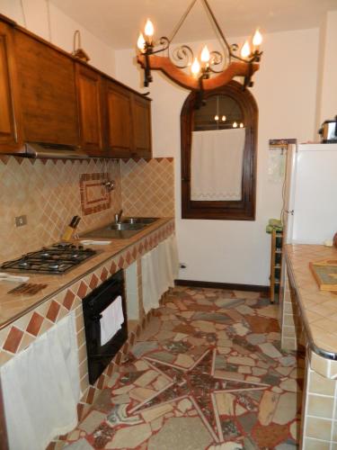 a kitchen with a tile floor with a fireplace at Castello in Valguarnera Caropepe